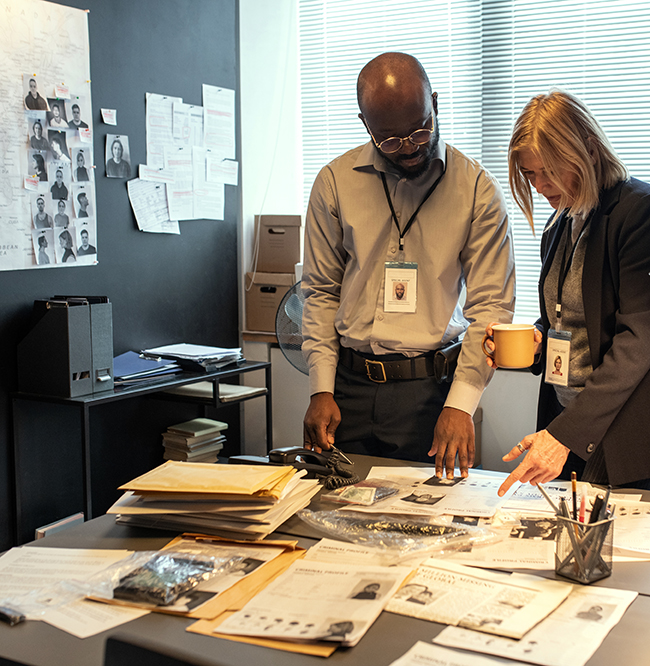 Two intercultural investigators in formalwear discussing personal information